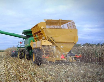 Photo of a Custom Cob Caddy being pulled behind a John Deere Combine while harvesting corn